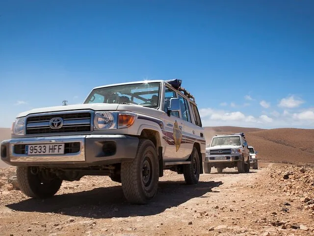 Toyota-Geländewagen auf einem Schotterweg unter blauem Himmel