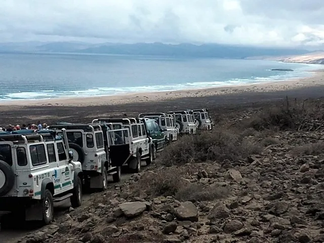 Eine Reihe geparkter Land Rover entlang eines unbefestigten Wegs in der Nähe des Cofete-Strandes